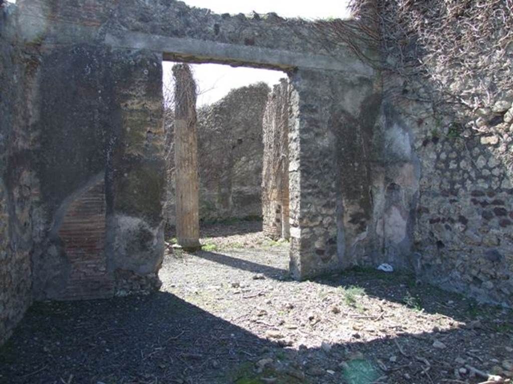 VIII.5.9 Pompeii. March 2009. Room 5, triclinium. South wall with doorway to north portico. According to Boyce, in the south-west corner of an undecorated room on the right of the tablinum was a small hearth. On the west wall was a rough painting of an aedicula with a small pediment and a door of two leaves thrown open. Two figures were seated within, indistinguishable in detail because of the fading of the colours and the crudeness of the painting. See Boyce G. K., 1937. Corpus of the Lararia of Pompeii. Rome: MAAR 14. (p.77, no.369)