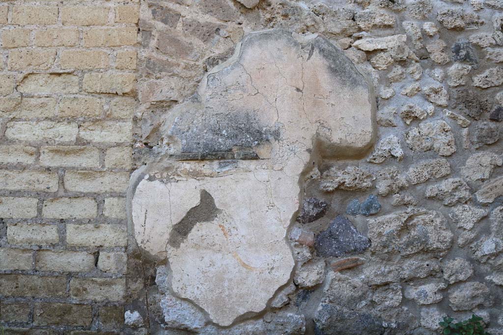 VIII.6.3 Pompeii. December 2018. 
Looking towards west wall in kitchen, with remains of lararium painting. Photo courtesy of Aude Durand.
According to Boyce, on the west wall of a room which was perhaps a kitchen, was a partially preserved lararium painting.
In the upper zone, the feet of the Genius, to the right of him, a Lar in red and blue tunic, again to the right a long staff, perhaps with sausages attached to it.
Below the figure of the Genius, a tile was embedded in the wall to hold offerings.
Below this, was a serpent (black with a yellow belly, red crest and beard) advancing towards a second serpent (smaller and all black with crest).
This second serpent was coiled around a black omphalos covered with a green net and standing upon a rectangular base.
See Boyce G. K., 1937. Corpus of the Lararia of Pompeii. Rome: MAAR 14. (p.78, no.373) 
According to Giacobello, the picture on the west wall of kitchen has not been conserved.
The small service area was located in the south-west corner of the house.
See Giacobello, F., 2008. Larari Pompeiani: Iconografia e culto dei Lari in ambito domestico. Milano: LED Edizioni. (p.204).