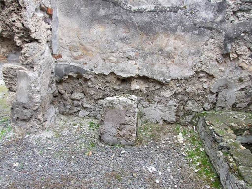 IX.1.12 Pompeii. December 2007. South wall and south-east corner near doorway of kitchen. Masonry altar.
According to Boyce, the lararium painting was done on a white background.
When he wrote his book in 1937, he said that on the right and left, the legs of the figures of the Lares were preserved.
In the middle was the lower part of Venus Pompeiana wearing a yellow chiton and blue mantle.
In her left hand she held a sceptre, and her right rested on a rudder.
At her side was a cupid who seemed to be leaning forward to touch the garment of the goddess.
Below this, the two serpents confronted at a painted altar.
On the floor below the painting a masonry altar stands against the wall.
See Boyce G. K., 1937. Corpus of the Lararia of Pompeii. Rome: MAAR 14. (p.79)  
See Giacobello, F., 2008. Larari Pompeiani: Iconografia e culto dei Lari in ambito domestico. Milano: LED Edizioni. (p.204, no.96).
Remains of the altar and household shrine recorded by Helbig: Kitchen: Venus Pompeiana and Gods, 66?  
See Helbig, W., 1868. Wandgemälde der vom Vesuv verschütteten Städte Campaniens. Leipzig: Breitkopf und Härtel. (66).
See Pappalardo, U., 2001. La Descrizione di Pompei per Giuseppe Fiorelli (1875). Napoli: Massa Editore. (p.138)
See Fiorelli, G. (1875). Descrizione di Pompei, (p.370)