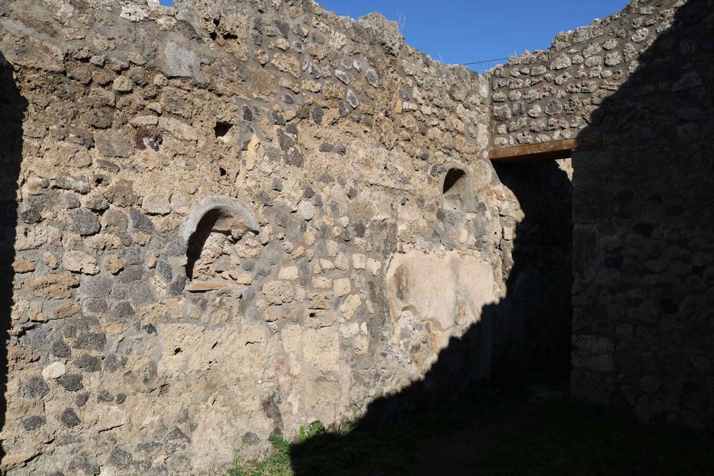 IX.2.11 Pompeii. December 2018. 
Looking east along north wall, with two niches, and doorway to rear room. Photo courtesy of Aude Durand.
