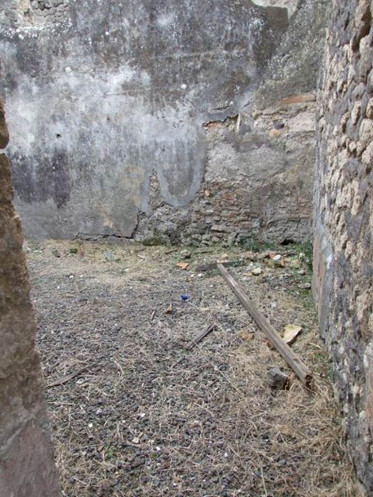 IX.2.16 Pompeii. December 2007. Doorway to room on south side of corridor, described by Boyce as the triclinium. He said that on the north wall was a panel of white stucco bordered in red and within it was the lararium painting in two zones. The two Lares stood in the upper zone, both with rhyton and situla, and the Genius stood between them pouring a libation onto an altar. On the other side of the altar was the tibicen.  In the lower zone, one yellow serpent was advancing left towards a painted altar of yellow marble with one egg.
See Boyce G. K., 1937. Corpus of the Lararia of Pompeii. Rome: MAAR 14.  (p.81, no.394)
According to Trendelenburg in BdI, “from the fauces, a side door gave access to a square room. The original decoration was not conserved, other than some traces of figurines placed in the red and black divisions on the wall, and the painted lararium divided into two zones”.
See Trendelenburg in BdI, 1871, (p.201)
According to Fiorelli, “Dal tablino, e dalla fauce che vi si trova accanto, nel cui estremo e situato il triclinio, si passa nel giardino, che ha un larario…….” “From the tablinum, and from the corridor that one finds nearby, in whose extremity was situated the triclinium, one passes into the garden, that had a lararium with the painting of a Genius sacrificing being assisted by a tibicen. There were also two Lares and a serpent advancing towards the table. Following on was a storeroom (apotheca), a masonry staircase to the upper floor, the kitchen and the latrine, placed beneath the abovementioned stairs, and another room, occupied perhaps by a servant that guardedthe door”.
See Pappalardo, U., 2001. La Descrizione di Pompei per Giuseppe Fiorelli (1875). Napoli: Massa Editore. (p.142-3)
See Fiorelli, G., 1875. Descrizione di Pompei, (p.384)
According to Giacobello, the picture was in an apotheca (o) on the north wall, but is no longer visible, only Boyce’s description remains.
See Giacobello, F., 2008. Larari Pompeiani: Iconografia e culto dei Lari in ambito domestico.  Milano: LED Edizioni. (p.204-5)