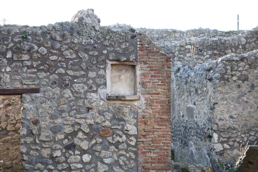 IX.3.20 Pompeii. December 2018. Room 1, looking towards west wall with niche. Photo courtesy of Aude Durand.
According to Boyce, this rectangular niche with ledge had a lararium painting on the wall at its side.
The Genius with the assistance of tibicen and camillus performed a sacrifice at the altar.
The Camillus was very small and carried an urceus in one hand and a patera in the other.
A Lar stood on each side.
Below, a single serpent approached an altar complete with offerings.
See Boyce G. K., 1937. Corpus of the Lararia of Pompeii. Rome: MAAR 14. (p. 84, 417) 
See Pappalardo, U., 2001. La Descrizione di Pompei per Giuseppe Fiorelli (1875). Napoli: Massa Editore. (p. 147)
See Trendelenburg in Bullettino dell’Instituto di Corrispondenza Archeologica (DAIR), 1871, p.207.