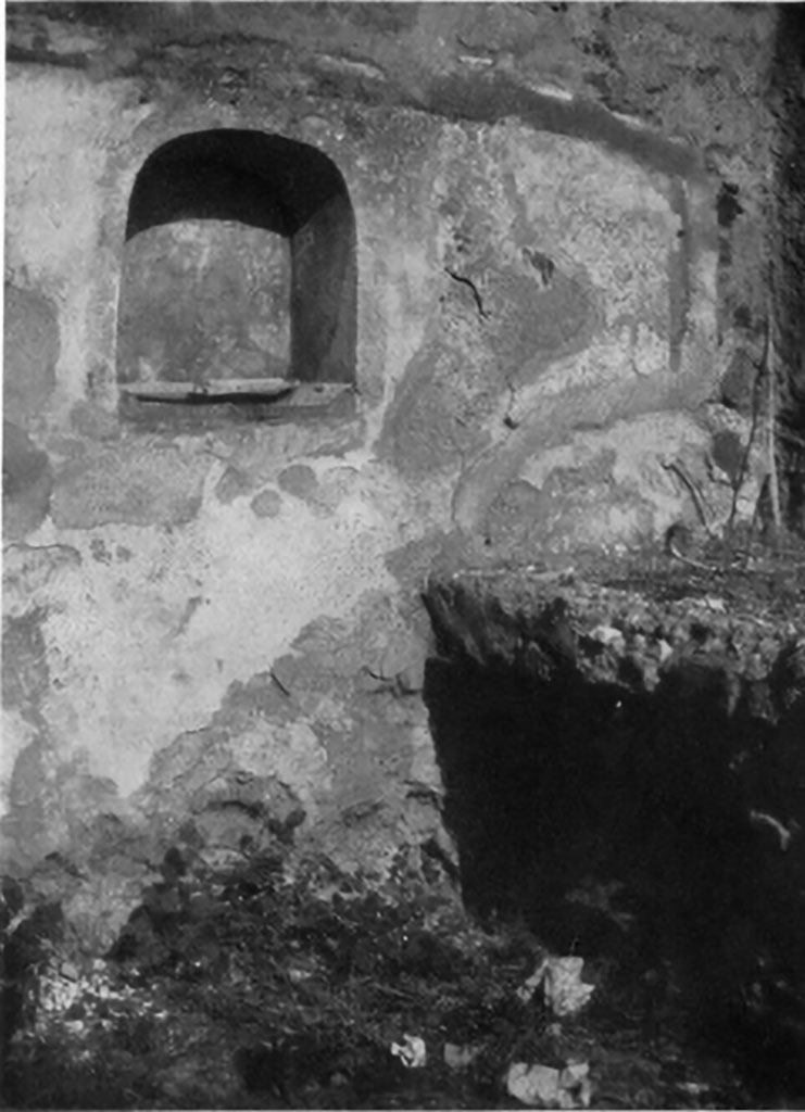 IX.5.9 Pompeii. 1930s photo by Tatiana Warscher. Room “n”, arched niche in north wall of kitchen. 
According to Boyce –
In the north wall near the hearth, is an arched niche (h.0.55, w.0.50, d.0.30, h. above floor 1.10), on the wall on each side of which is painted  a burning altar, with a yellow serpent gliding towards it between plants and flowers.
See Boyce G. K., 1937. Corpus of the Lararia of Pompeii. Rome: MAAR 14. (p. 86, no. 423, Plate 2,4). 
See Giacobello, F., 2008. Larari Pompeiani: Iconografia e culto dei Lari in ambito domestico. Milano: LED Edizioni, (p.207, no.101)
