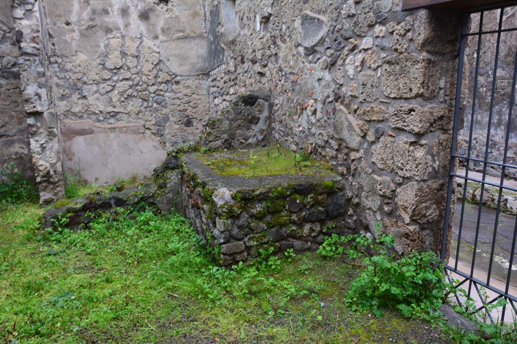 IX.5.11 Pompeii. March 2017. Room r, looking north-east towards hearth, with doorway at IX.5.13, on right. 
Foto Christian Beck, ERC Grant 681269 DÉCOR.
According to Boyce –
In the kitchen entered from the east side of the peristyle and having separate communication with the street at IX.5.13, in the north wall is a rectangular niche (h.0.40, w.0.45, d.0.20, h. above floor 0.95), and on the wall beside it are faint traces of the original lararium painting.
He gives the reference - Bull. Inst. 1879, p.195, which says - .
“Fra l’ingresso e il focolare evvi nel muro nord la nicchia de’Lari e deboli tracce della pittura lararia”.
(Between the entrance and the hearth, there is in the north wall faint traces of the niche of the Lares and lararium painting).
See Boyce G. K., 1937. Corpus of the Lararia of Pompeii. Rome: MAAR 14. (p.86, no.424).
(Note: it looks like the north wall at rear of the hearth has fallen).
).