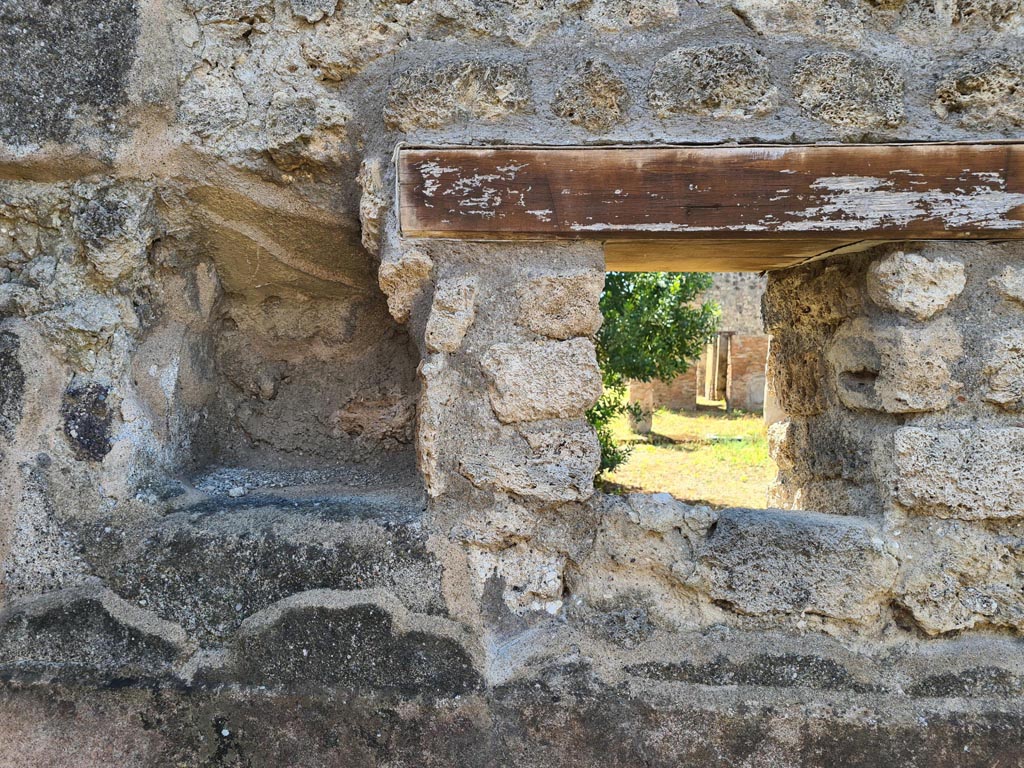 IX.6.7 Pompeii. May 2024. 
Kitchen “p”, west wall at south end with window onto peristyle of IX.6.5, and in the same corner a niche (0.40 high x 0.33 wide) that could have been used as a lararium or for putting a light, or for the figurines of the Lares: a lararium painting was not found.
See Mau in Bullettino dell’Instituto di Corrispondenza Archeologica (DAIR), 1880, (p.231).
See Boyce G. K., 1937. Corpus of the Lararia of Pompeii. Rome: MAAR 14. (p.86, no. 431).
Photo courtesy of Klaus Heese.
