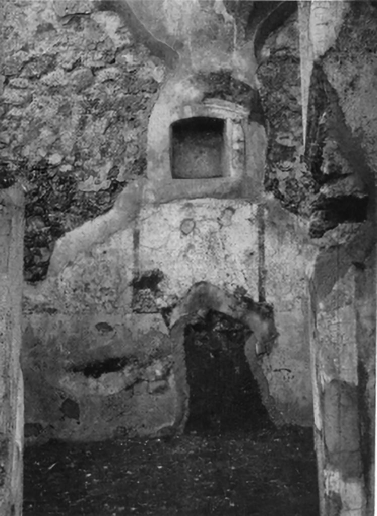 IX.6.g Pompeii. Niche set into west wall of room in north-west corner of peristyle.
According to Boyce –
in a small room in the north-west corner of the peristyle, in the middle of the west wall was an arched niche (h.0.32, w.0.31, d.0.15, h. above floor 1.42). 
This was adorned with an aedicula façade of applied half-columns on each side supporting a cornice.
The cornice ran around the curve of the arch instead of a pediment.
The lower half of each column was red, the upper half white.
The inside walls of the niche were decorated with many small irregular blotches of red on a white background.
See Bullettino dell’Instituto di Corrispondenza Archeologica (DAIR), 1881, p. 23.
See Boyce G. K., 1937. Corpus of the Lararia of Pompeii. Rome: MAAR 14. (p. 87, no.435 and Pl.3, 6).