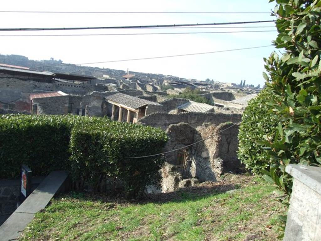 Looking north-west from Casina dell’ Aquila to rear of IX.7.14. December 2007. According to Boyce and Jashemski, a garden was excavated near here. The west wall of the garden can be partially seen on the right side of the doorway of IX.7.14. Whether it belonged to IX.7.12, 14, or 16 cannot be seen until further excavation. See Boyce G. K., 1937. Corpus of the Lararia of Pompeii. Rome: MAAR 14. (p.89, no.445)  According to Jashemski, she quoted the location as IX.7.12(?). She said in the north-west corner of this partially excavated garden, at the left of the entrance, stood an aedicula lararium. In front of the lararium was a small altar, and a lararium painting on the wall around the shrine. Many marble sculptures decorated the garden. See Jashemski, W. F., 1993. The Gardens of Pompeii, Volume II: Appendices. New York: Caratzas. (p.239)