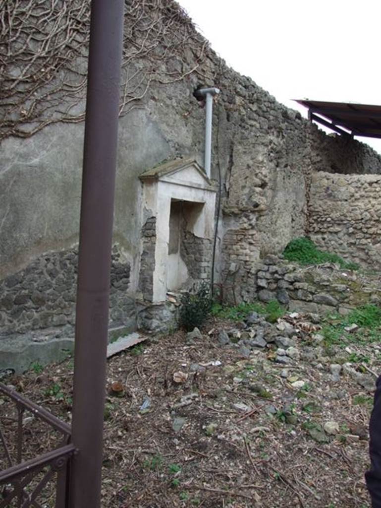 IX.7.20 Pompeii. December 2007. Aedicula with niche on north side of fountain.
According to Boyce –
In the centre of the west wall of the garden is a fine mosaic fountain and on each side of it a simple aedicula (h.3.0), consisting of a rectangular niche (h.1.52, w.0.81, d.0.51) enclosed by walls built on the top of the rectangular podium (1.40 by 0.32, h.0.80).
The opening of the niche is framed by two pilasters which seem to support the simple architrave and pediment above them.
The base is coated with red stucco, the upper part of the structure with white, including the interior of the niche, the back wall of which is outlined in green.
Within the niche on the right of the fountain were found five terracotta statuettes.
He quotes references – Not. Scavi, 1881, 24; Bull. Inst., 1883, 154.
See Boyce G. K., 1937. Corpus of the Lararia of Pompeii. Rome: MAAR 14. (p.89, no. 446).