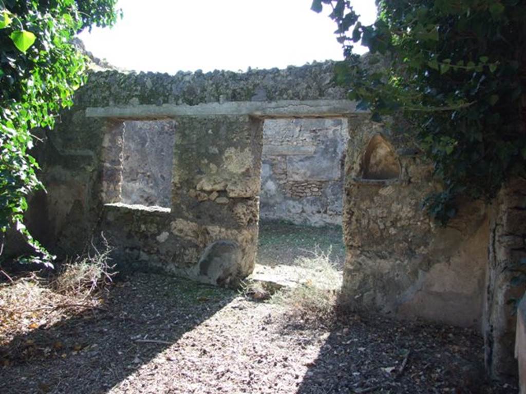 IX.9.11 Pompeii.  March 2009.  Niche on west wall of atrium, with doorway and window to Room 6, Garden.