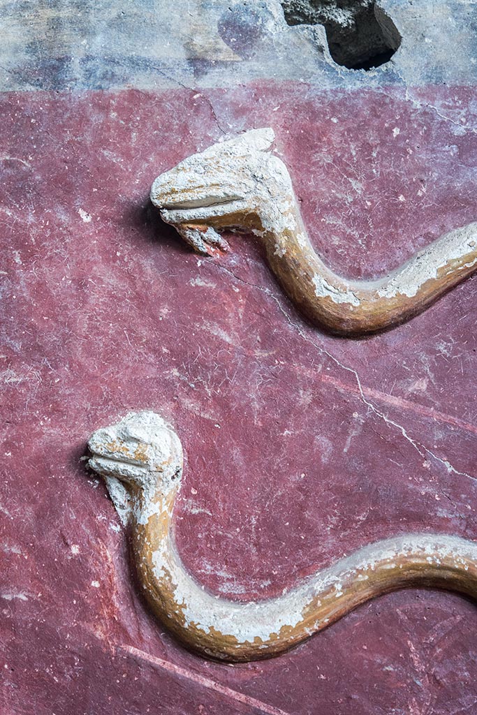 IX.10.1, Pompeii. July 2024. 
Room 12, detail of stucco serpents from centre of upper south wall. Photo courtesy of Johannes Eber.