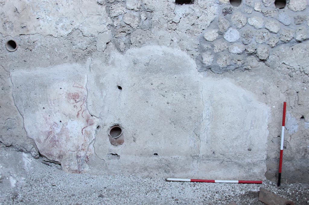 IX.12.9 Pompeii. May 2023.  
Room 13, west wall of kitchen on west side. Next to the room where the skeletons were found was a kitchen, with a stone counter.
Above the kitchen counter were traces of a domestic shrine in the form of a fresco which appears to depict the household gods (Lares) and a ceramic pot partly set into the wall which may have been used as a container for religious offerings.
See PAP: New victims from Pompeii emerge from the excavation of the house of the chaste lovers
Ambiente 13, parete o0vest della cucina sul lato ovest. Accanto alla stanza in cui sono stati trovati gli scheletri c'era una cucina, con un bancone in muratura.
Sopra il bancone della cucina, le tracce di un Santuario domestico sotto forma di un affresco che sembra raffigurare i Lares della casa et un vaso di ceramica parzialmente incassata ne muro che potrebbe essere stato utilizzato come ricettacolo di offerte religiose.
Vedi PAP: Pompei due scheletri rinvenuti sotto un crollo di muro
Photograph © Parco Archeologico di Pompei.
See/Vedi E-Journal, Scavi di Pompei, Vol. 1, p. 4, Fig. 3 PAP E-Journal_01 (PDF)