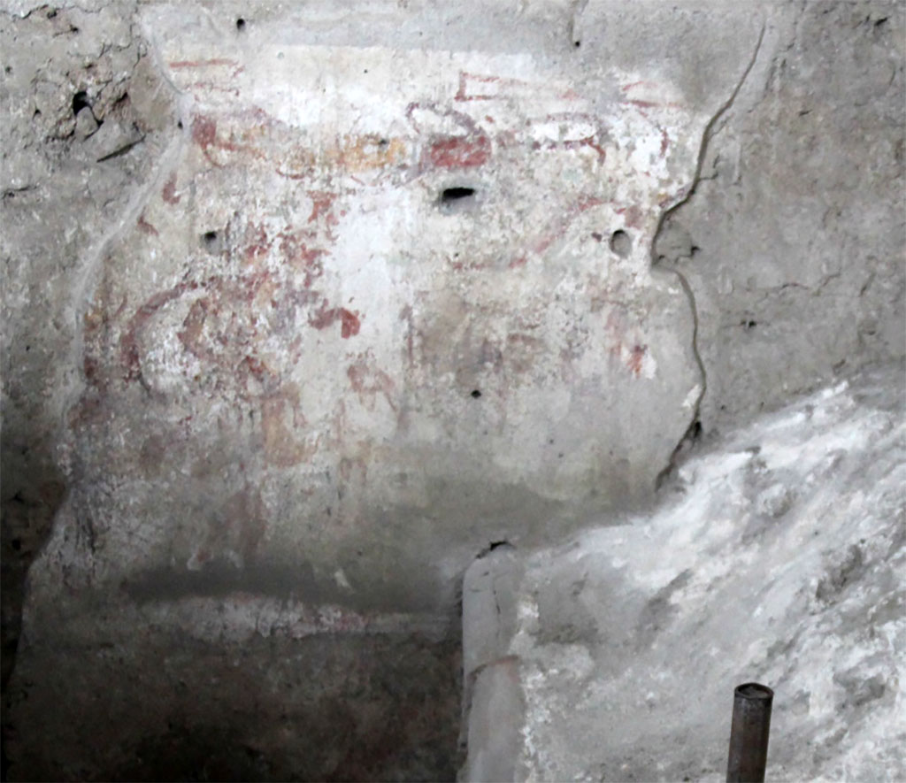 IX.12.9 Pompeii. May 2023.  
Room 13, south wall of kitchen on west side.
A male figure with a short tunic and cornucopia, interpretable as a lar.
Ambiente 13, parete sud della cucina sul lato ovest.
Una figura maschile con tunica corta e cornucopia, interpretabile come lare.
Photograph © Parco Archeologico di Pompei.
See/Vedi E-Journal, Scavi di Pompei, Vol. 1, p. 4, Fig. 2 PAP E-Journal_01 (PDF)