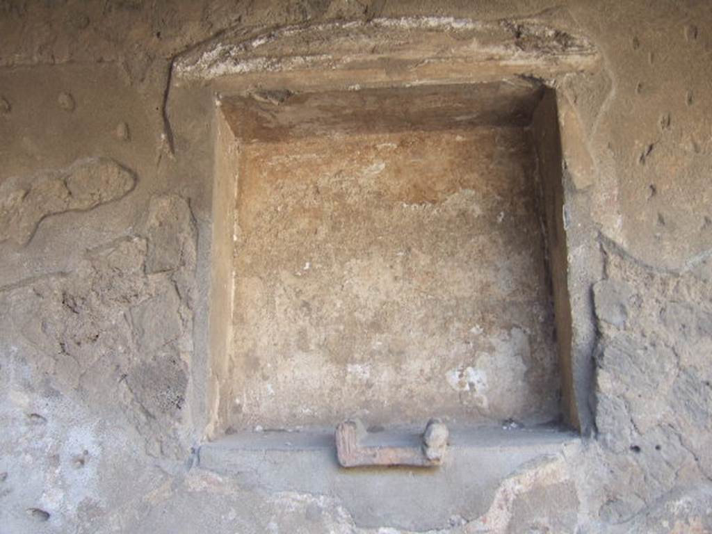 Villa of Mysteries, Pompeii. May 2006. Room 61, niche in north wall, with remains of stucco pediment above. According to Boyce, the small altar embedded in the floor of the niche, was decorated with an image of a gorgon and two heads of bulls. Two sculptured heads, a terracotta one of a goddess and another of tufa representing Hercules, were found inside the niche. See Boyce G. K., 1937. Corpus of the Lararia of Pompeii. Rome: MAAR 14. (p.97)
