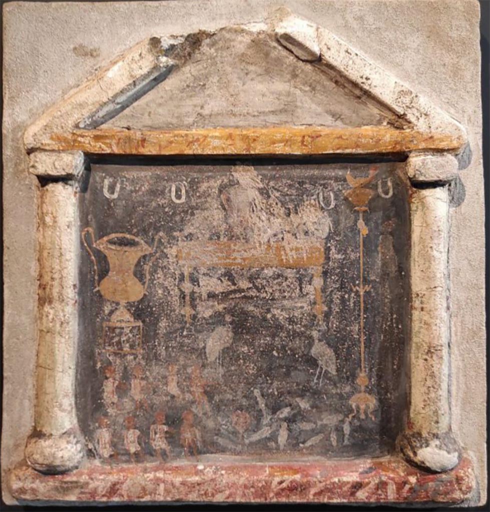 Stabiae, Villa Arianna, room 56. Stuccoed and painted lararium with an aedicula and two small columns supporting a pediment with marble painting.
According to Sodo, in the foreground are eight fishermen drawing in their nets full of fish. Behind is a golden couch with two wading birds aside it. 
To the left is a silver kantharos and to the right a tall candelabra with a golden lamp.
Room 56 is situated on a ramp. It is a large room opening on to the bay and has no decoration preserved. 
It is one of six rooms on the fourth floor of the villa ground level, preceded by a corridor and most likely used as storerooms or dwellings.
Now in Stabia Antiquarium, inventory number 69167.
See Otium Ludens, curated by Guzzo, P, Bonifacio, G, and Sodo, A.M. (2007). Castellammare di Stabia: Nicola Longobardi, p. 145.