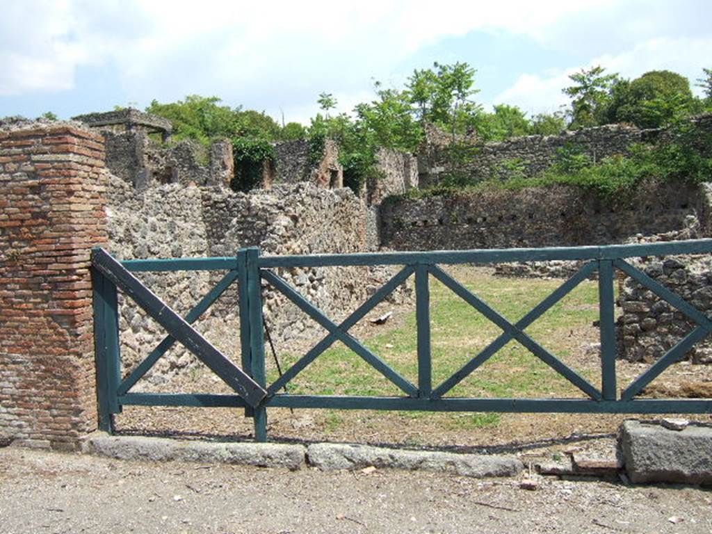 I.1.8 Pompeii. September 2005. Entrance.  On the north (left) wall of the vestibule was formerly a Lararium painting - now destroyed.  Beside a round altar stood the Genius, performing a sacrifice with the aid of tibicen and camillus, the latter of whom carried a shallow dish in one hand. The two Lares were on either side.  Around the altar was a coiled serpent.  In the lower zone there were two other serpents, one on each side of a masonry projection above which was painted a pine cone.  
Between these two serpents was the figure of a man pouring wine from an amphora into a Dolium.  Above his head was written the name of Hermes (CIL IV 3355).  Presumably the name of the proprietor of the Hospitium.  Opposite the painting, leaning against the south (right) wall, was a hearth for cooking. Near to the hearth was the door that led to No.6.
See Boyce G. K., 1937. Corpus of the Lararia of Pompeii. Rome: MAAR 14. (p.21) 
See Della Corte, M., 1965.  Case ed Abitanti di Pompei. Napoli: Fausto Fiorentino. (p.265)
See Fröhlich, T., 1991. Lararien und Fassadenbilder in den Vesuvstädten. Mainz: von Zabern. (p.249, L2)
See Pappalardo, U., 2001. La Descrizione di Pompei per Giuseppe Fiorelli (1875). Napoli: Massa Editore. (p.33)