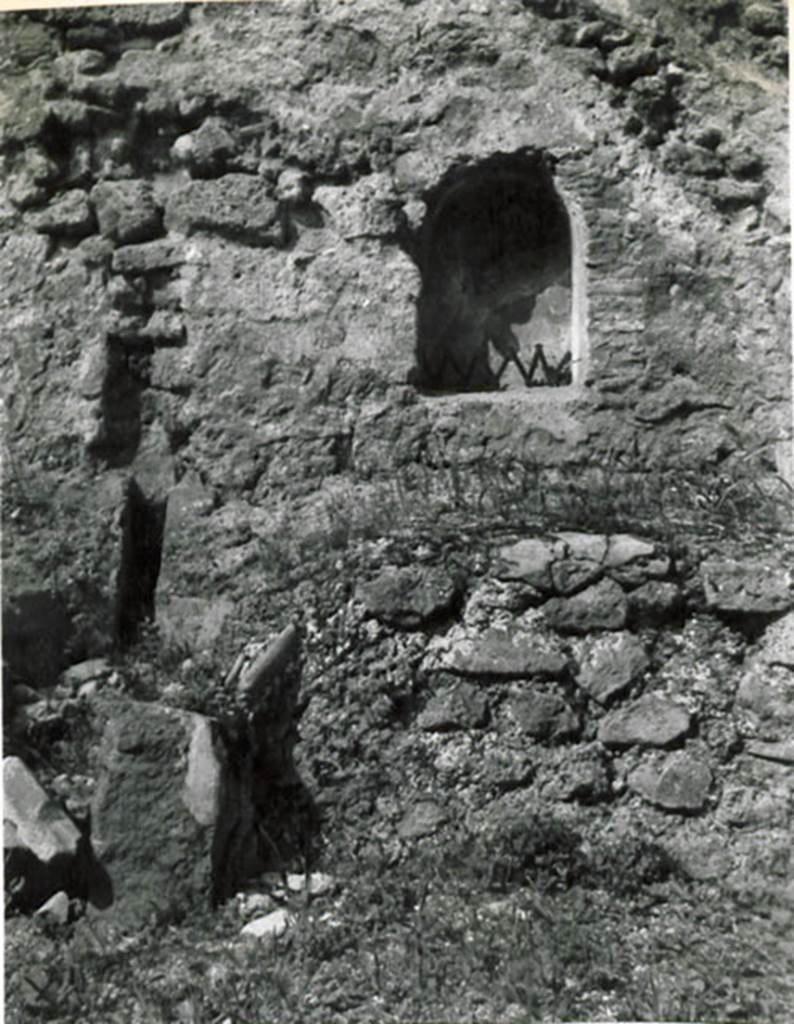 I.3.15 Pompeii. 1935 photograph taken by Tatiana Warscher. Looking towards arched niche in west wall.
See Warscher, T, 1935: Codex Topographicus Pompejanus, Regio I, 3: (no.31), Rome, DAIR, whose copyright it remains.  
According to Warcher, quoting Fiorelli, “On the right of this workshop were the first steps of the stairs that went up to the upper floor, under which was a podium, with furnace in the middle to accommodate a large boiler, which was used as a laundry. Embedded in nthe wall was the niche for the Lares”.