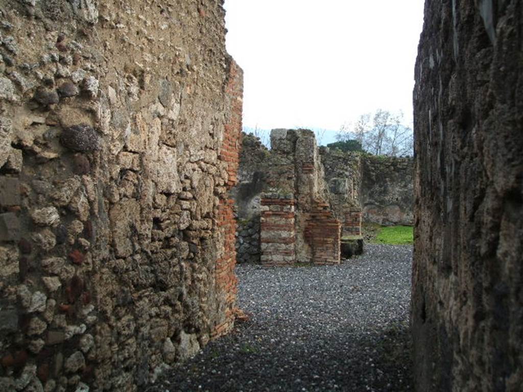 I.3.20 Pompeii. December 2007. Looking south along entrance corridor towards atrium and rear of peristyle.
According to Boyce, on the right side of the peristyle stood a small altar, coated with stucco. 
On the yellow background, there were painted festoons and masks.
The excavation report called it a lararium.
He gives the reference Bull. Inst., 1869, 242.
This is no longer in situ.
See Boyce G. K., 1937. Corpus of the Lararia of Pompeii. Rome: MAAR 14. (p. 24)