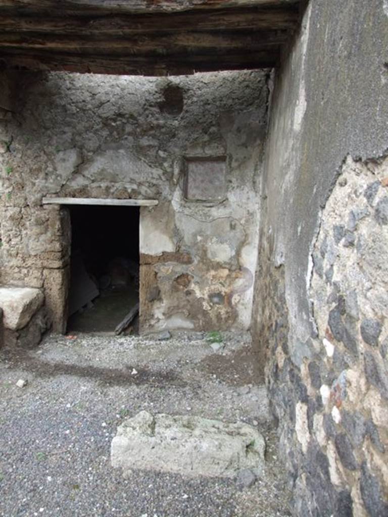 I.8.10 Pompeii. March 2009. Area on north-east of peristyle. Doorway to underground kitchen with a latrine, and niche on north wall. According to Jashemski, on both sides of the door leading to the basement room was a Lararium. The one on the left was already destroyed at the time of its discovery (the excavations started in the years immediately preceding World War II, were suspended in 1941, and were completed around the beginning of the 1950’s). The one on the right was well preserved, with painting of serpents, altar and 2 Lares, now however, less visible. The niche is decorated with flowers that have the appearance of poppies.
See Jashemski, W. F., 1993. The Gardens of Pompeii, Volume II: Appendices. New York: Caratzas. (p.42)