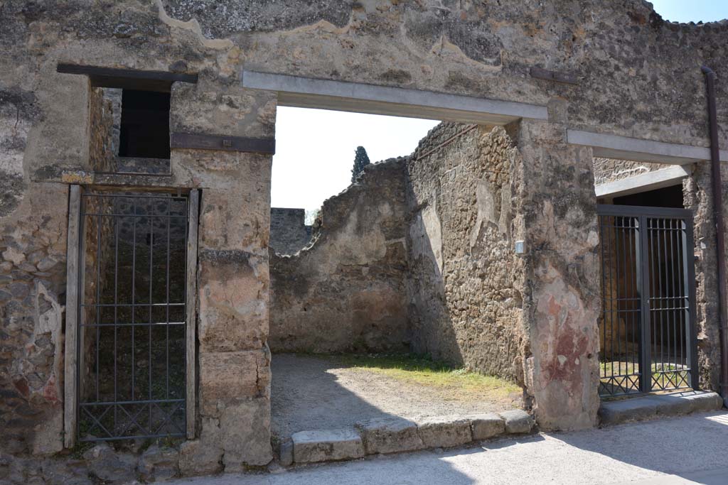 I.10.5, Pompeii, (on left), I.10.6 (in centre) and I.10.7 (on right). April 2017.
Looking south to entrance doorways on Vicolo del Menandro. Photo courtesy Adrian Hielscher.