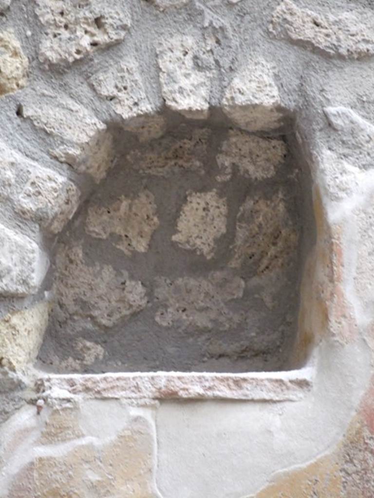 I.11.6 Pompeii. March 2009. Room 6, niche. Arched niche on east side of south wall in garden. According to Giacobello, the niche was found on a wall frescoed in yellow and was part of a painted wall decoration. The niche was made in the last period of the house, when the interior decoration of the garden was done. See Giacobello, F., 2008. Larari Pompeiani: Iconografia e culto dei Lari in ambito domestico.  Milano: LED Edizioni. (p.257)