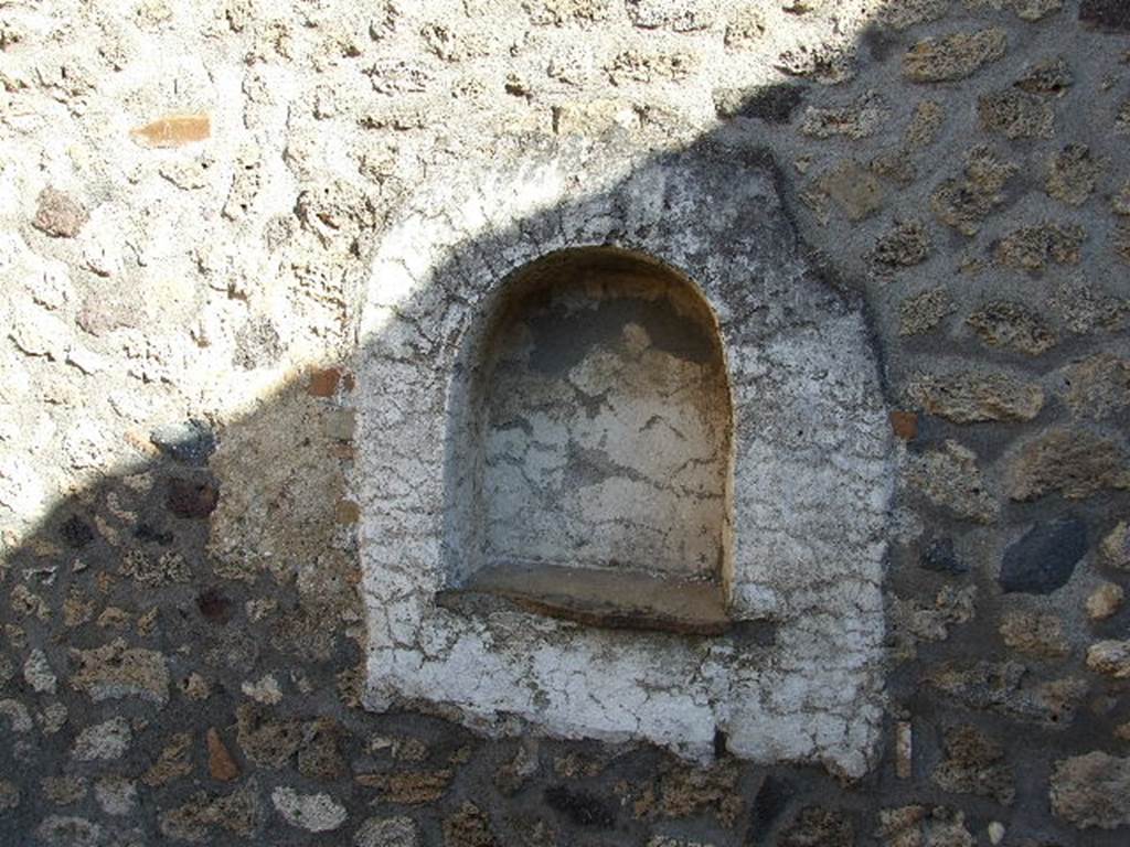 I.11.13 Pompeii. December 2006. 
Arched niche lararium on east wall. The niche and surrounding wall panel were plastered and painted white.
See Giacobello, F., 2008. Larari Pompeiani: Iconografia e culto dei Lari in ambito domestico.  Milano: LED Edizioni. (p.258, no.V16)
(She locates the lararium niche as being on the south wall).