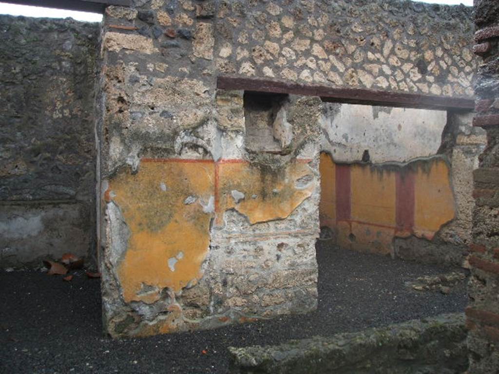 I.13.11 Pompeii. December 2004. Looking west across garden area.
Doorways to cubiculum on left, and oecus on the right, on west side of garden, with lararium niche between. According to PPP, on the west wall between doorways was the lararium niche, with serpent, red flowers and red border, much decayed. See Bragantini, de Vos, Badoni, 1981. Pitture e Pavimenti di Pompei, Parte 1. Rome: ICCD. (p.189)
According to Fröhlich and Giacobello, the rectangular niche was painted on its inside walls with red flowers, no longer conserved.  There may have been two statuettes found in this lararium, Hercules and Minerva.
See Fröhlich, T., 1991. Lararien und Fassadenbilder in den Vesuvstädten. Mainz: von Zabern. (L31)
See Giacobello, F., 2008. Larari Pompeiani: Iconografia e culto dei Lari in ambito domestico.  Milano: LED Edizioni. (p.233)
According to PPM, the lower yellow zoccolo was divided into two panels by a vertical red band. On the south end was a painted vignette showing two doves with cherries, and at the north end under the niche was the painted lararium showing two serpents approaching a central altar with eggs.
See Carratelli, G. P., 1990-2003. Pompei: Pitture e Mosaici. Vol.II  Roma: Istituto della enciclopedia italiana. (p.916).