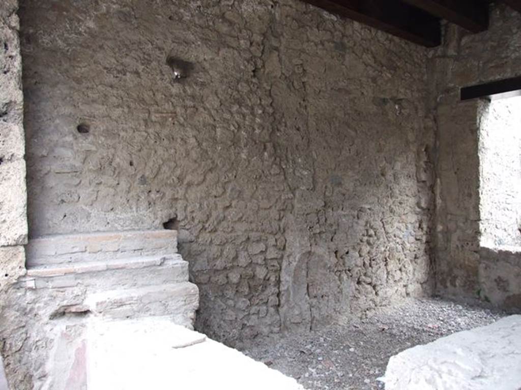 II.1.1 Pompeii. December 2006. Counter and east wall. 
In the south-east corner there was a niche of a lararium to Venus which is no longer visible.
According to Boyce, the arched niche (h.0.28, w.0.35, d.0.20, h. above floor 1.50) on the east wall had a painted blue border. 
In front of it stood a small table (0.48 by 0.17) decorated with metopes.
Nothing was found in the niche, but when the soil under the niche was investigated, fragments of a pseudo-alabaster statuette of Venus was found.
It was of very rough workmanship but had been gilded originally. 
In front of the image of the goddess stood a small altar of terracotta.
See Boyce G. K., 1937. Corpus of the Lararia of Pompeii. Rome: MAAR 14. (p. 30, no. 61)
Boyce gives a reference to Not. Scavi 1917, 251, with a photograph of the statuette, on p. 253.
.