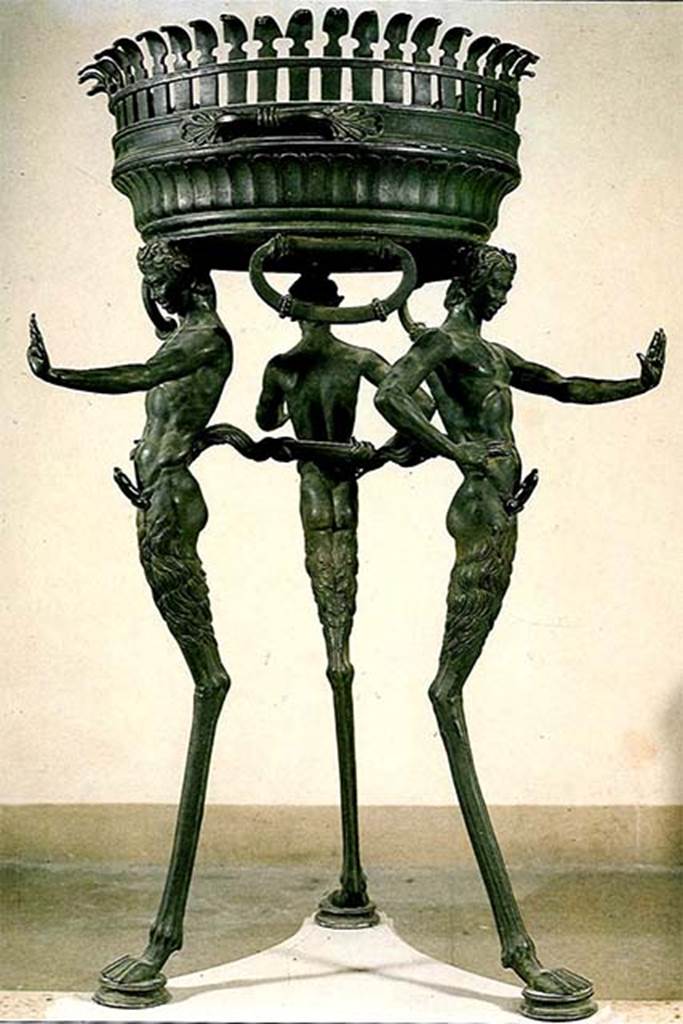 II.4.6 Pompeii. Found in the sacrarium 15th June 1755.
Bronze brazier tripod supported by three ithyphallic satyrs as legs.  
Now in Naples Archaeological Museum. Inventory number 27874.
