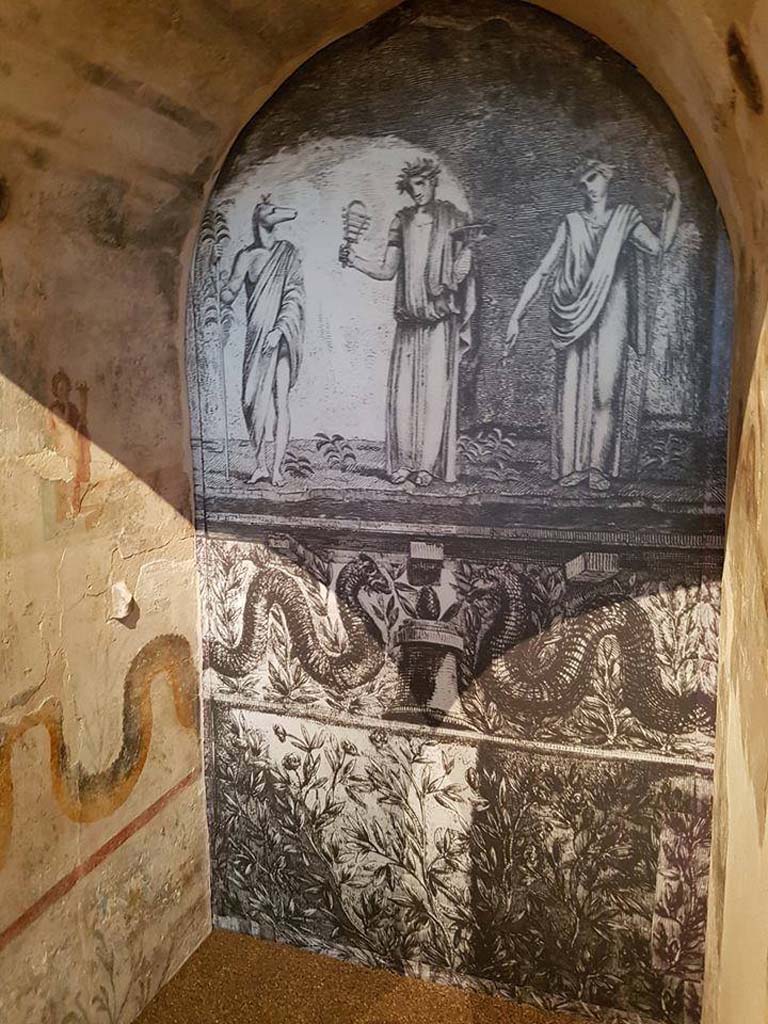 II.4.6 Pompeii. June 2016. Reconstruction of niche from sacrarium, looking towards rear.
According to Boyce’s description, Piranesi's print (here shown on the rear wall) is inaccurate in that Isis should be seated upon a throne but is standing in the centre.
See Boyce G. K., 1937. Corpus of the Lararia of Pompeii. Rome: MAAR 14.  (p.95, no.471)
Photograph © Parco Archeologico di Pompei.