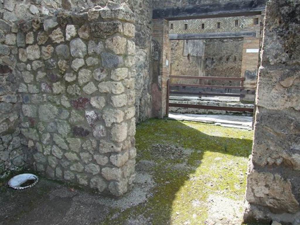 V.1.15 Pompeii. April 2009. Doorway to room on south side of entrance, leading into V.1.16. Looking west.
According to Boyce, in this area should have been the lararium, presumably destroyed in 1943.
He described it as being in a house transformed into a workshop.
In the west wall of the atrium, near the south-west corner was a rectangular niche (h.0.53, w.0.63, d.0.22, h. above floor 1.25) with aedicula façade and projecting floor.
The inside walls were painted blue and the opening of the niche was outlined with red stripes on the white background of the wall of the room.
See Boyce G. K., 1937. Corpus of the Lararia of Pompeii. Rome: MAAR 14. (p.32, no.74) 
)
