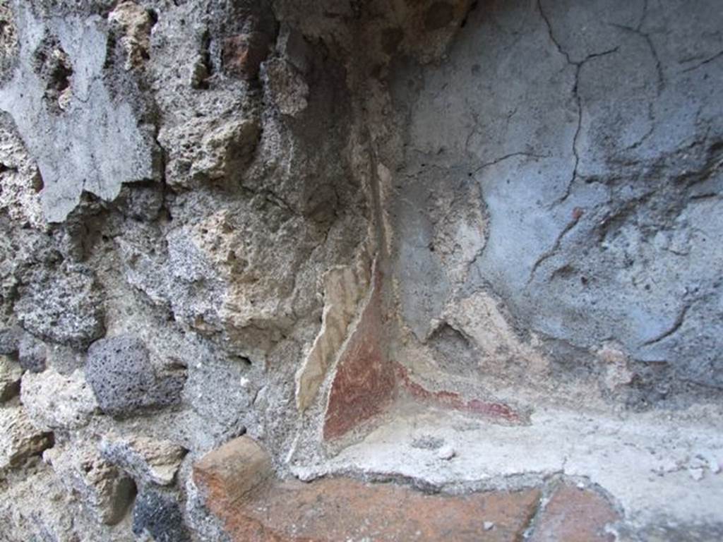 V.2.15 Pompeii. December 2007.  Room 9.  Lararium. Remains of several layers of superimposed decorated painted plaster in niche.  According to Boyce, red flowers were painted on the earlier white stucco on the side walls.  On the rear wall was a figure in yellow, perhaps a Lar, but only his feet were visible.  Today, nothing remains.   See Boyce G. K., 1937. Corpus of the Lararia of Pompeii. Rome: MAAR 14.  (No.95B on p.35)