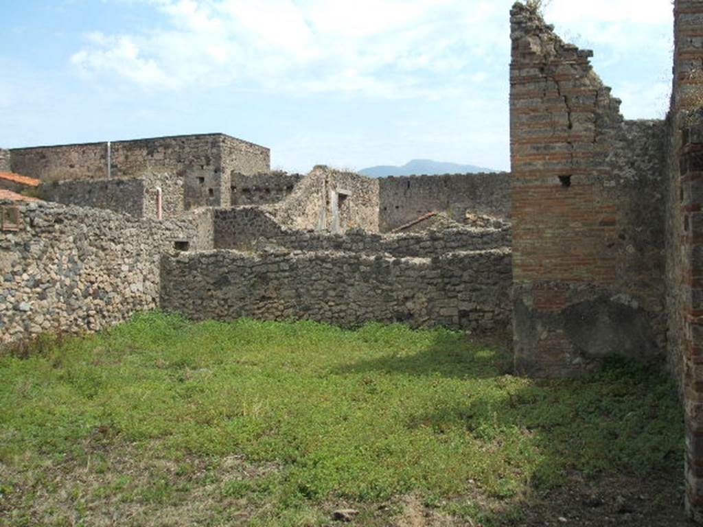 V.2.g Pompeii. Looking south across garden area.
According to Boyce, a slab with a phallus in relief could be found high on the east garden wall (2.50m above the ground).
This was surrounded by an aedicula façade, and was all painted red.
He said that another similar slab could be found against the west wall of the small space preceding the north portico.
Above a masonry bench and embedded in the west wall was a slab of tufa surrounded by an aedicula façade.
This would have been 1.30m above the ground. In the centre of the tufa slab was another phallus in relief.
See Boyce G. K., 1937. Corpus of the Lararia of Pompeii. Rome: MAAR 14. (p.36, no.105) 
According to Jashemski, the garden had a wide portico on the north supported by two columns and two pillars.
This was reached by the passageway to the left of the tablinum.
There was a masonry biclinium in the portico.
See Jashemski, W. F., 1993. The Gardens of Pompeii, Volume II: Appendices. New York: Caratzas. (p.112).
According to Soprano –
Ubicazione: viridario. L. medius, m.310; l. imus, m.2.65.
Bibliog.  Not.Scavi, 1896, p.421; Rom. Mitt, 1893, p.9.
Era un biclinio con piani inclinati. 
Il l. medius era addossato al muro occidentale del viridario. Non era visibile veruna traccia d’intonaco, ne vi sono resti della mensa.
See Soprano, P. (1950). I triclini all’aperto di Pompei. (In Pompeiana, raccolta di studi per il secondo centenario degli scavi di Pompei. Napoli, Gaetano Macchiaroli, Editore, p. 306, no.26).