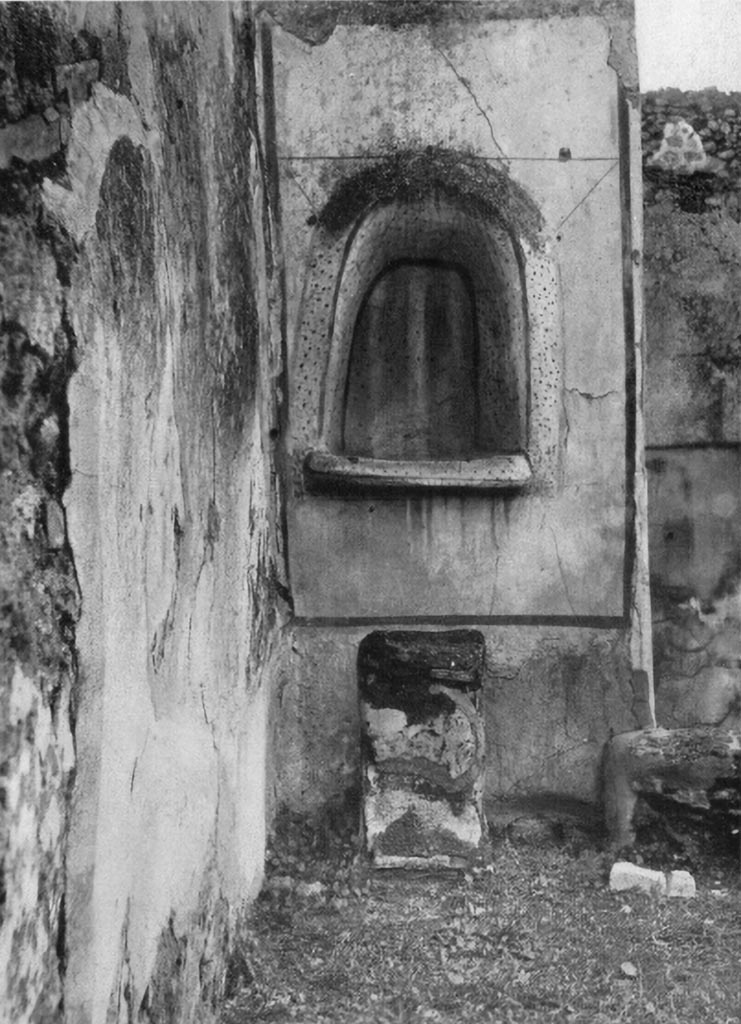 V.4.13 Pompeii. About 1937. Large irregular arched lararium niche in north-west corner of garden area, with masonry altar. It is set in a section coated with white stucco and marked off as a panel with broad red stripes.
See Boyce G. K., 1937. Corpus of the Lararia of Pompeii. Rome: MAAR 14. (p.41-2, no.126, Pl. 11,2).