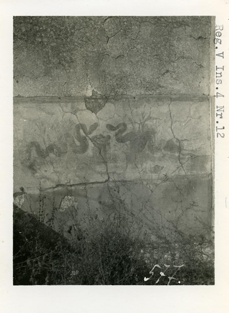 V.4.13 Pompeii but shown as V.14.12 on photo. Pre-1937-39. Two painted serpents.
Photo courtesy of American Academy in Rome, Photographic Archive. Warsher collection no. 577.
According to Boyce – 
Around the corner from this niche, on the west wall of the open area which preceded the garden on the north, was a broad sheet of white plaster.
On this plaster were painted two yellow serpents near a cylindrical altar with fruit, in the background were plants.
See Boyce G. K., 1937. Corpus of the Lararia of Pompeii. Rome: MAAR 14. (p.42, no.126, Pl. 11,2).