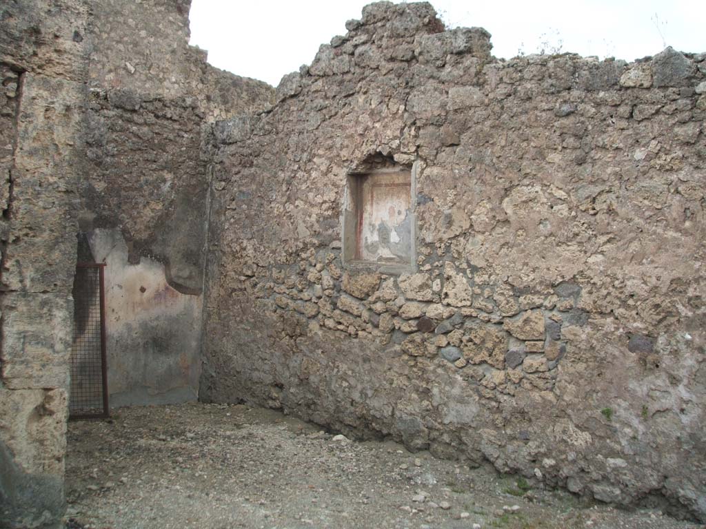 VI.7.9 Pompeii. May 2005. West wall of south ala, with niche with small painting of the head of the Gorgon.
According to Frohlich and Giacobello, on the west wall of the atrium, was a niche with a painted mask on a white background.
A painted lararium was also documented but of this there is no trace, according to them.
See Fröhlich, T., 1991. Lararien und Fassadenbilder in den Vesuvstädten. Mainz: von Zabern. (L63, Picture 34,1)
See Giacobello, F., 2008. Larari Pompeiani: Iconografia e culto dei Lari in ambito domestico.  Milano: LED Edizioni. (p.242)
According to Sogliano, in the kitchen was a painted lararium of an altar and a serpent nearby.
See Sogliano, A., 1879. Le pitture murali campane scoverte negli anni 1867-79. Napoli: (p.17, no.48).
(The kitchen would have been on the north side, at the rear of the stairs, and has not yet been photographed).
According to Boyce, Helbig wrongly assigned the shrine from VI.7.7, to VI.7.9 (see VI.7.7)
See Boyce G. K., 1937. Corpus of the Lararia of Pompeii. Rome: MAAR 14. (p.47, no.163, note 1)