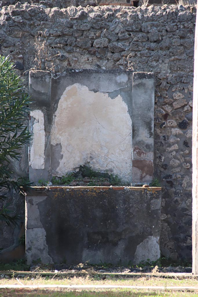 VI.7.20 Pompeii. October 2022.
Looking west to altar in peristyle. Photo courtesy of Klaus Heese. 
According to Boyce –
Against the west wall of the pseudo-peristyle stands a huge aedicula.
See Boyce G. K., 1937. Corpus of the Lararia of Pompeii. Rome: MAAR 14, (p.48, no.166).
See Giacobello, F., 2008. Larari Pompeiani: Iconografia e culto dei Lari in ambito domestico. Milano: LED Edizioni, (p.270 no.V45)