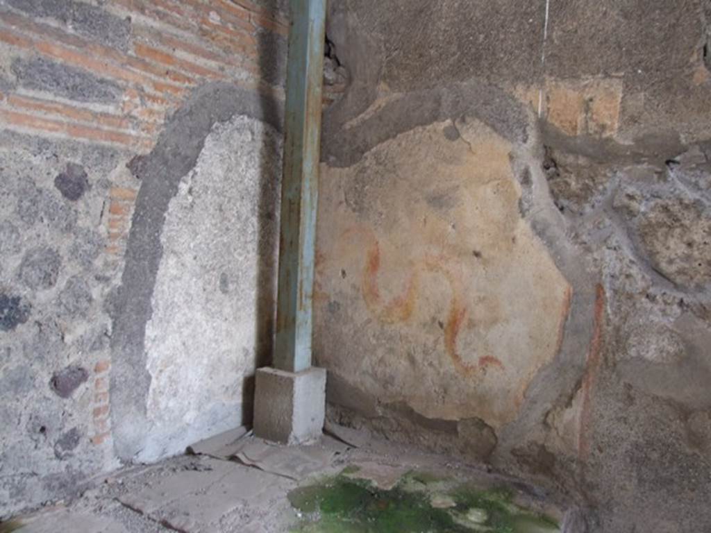 VI.9.7 Pompeii. March 2009. Room 4, painted lararium in north-west corner of kitchen.  
According to Boyce, in the north-west corner above the hearth is a painting of two red and yellow serpents. The one on the right has red crest and beard; the head of the other is destroyed. They approach an altar. There are garlands above.
See Boyce G. K., 1937. Corpus of the Lararia of Pompeii. Rome: MAAR 14.  (p.50, 178)