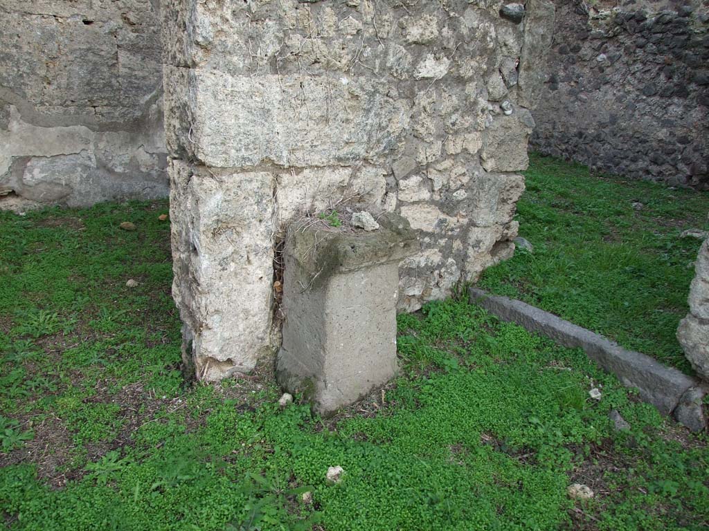 VI.11.19 Pompeii. December 2007. 
Household altar near east wall of atrium, with doorway to room 12, on left, and to room (11) on right.  
According to Boyce, against the east wall of the atrium, to the left of the entrance, stands an altar of tufa*.
This altar was apparently coated with a layer of stucco in the late days of the city.
On the wall above it were painted the two serpents confronted at a painted altar furnished with a pine cone.
See Boyce G. K., 1937. Corpus of the Lararia of Pompeii. Rome: MAAR 14. (p.51, no.188)
* note on page 51 reads – according to Pernice, “the altar dates from the earlier Tufa Period and still stands against the tufa wall where it was originally placed”. 
* see Pernice, Hellenistische Tische, 66 and pl. 40,1.
See Giacobello, F., 2008. Larari Pompeiani: Iconografia e culto dei Lari in ambito domestico. Milano: LED Edizioni. (p. 242)