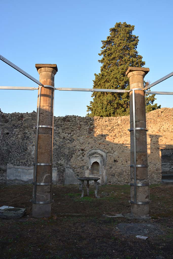 VI.13.13 Pompeii. October 2019. 
Looking west across peristyle towards aedicula lararium against west wall of garden area.
Foto Annette Haug, ERC Grant 681269 DÉCOR.
According to Boyce, against the west wall of the peristyle stands a simple aedicula (0.75 by 0.30, height 2.15).
Above a base (0.80) two side walls support a roof with small pediment, protecting a vaulted niche (h.0.76, w.0.43, d.0.40).
The whole structure is coated with a layer of white stucco.
See Boyce G. K., 1937. Corpus of the Lararia of Pompeii. Rome: MAAR 14. (p.52, no.195, and Pl.35,4). 
He quoted Not. Scavi 1876, 78, Bull. Inst. 1877, p. 164, 168)
See Giacobello, F., 2008. Larari Pompeiani: Iconografia e culto dei Lari in ambito domestico. Milano: LED Edizioni, (p.274 no.V51)
