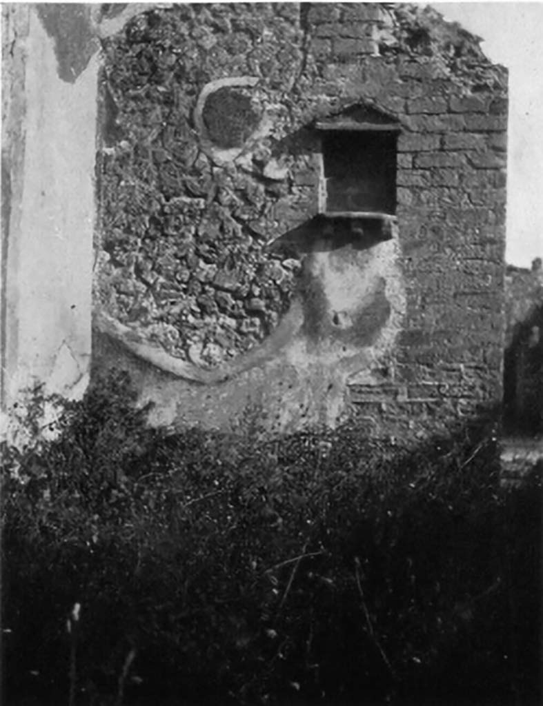 VI.14.5 Pompeii. 1930s photo of lararium by Tatiana Warscher.
According to Boyce, in the south wall of the atrium to the right of the entrance is a rectangular niche.
It is adorned with a pediment on the wall above it, and a ledge supported by three brackets, projects on the level of the floor.
These are all formed by tiles embedded into the wall and presumably all originally covered with stucco.
See Boyce G. K., 1937. Corpus of the Lararia of Pompeii. Rome: MAAR 14. (p.52, no.197, and Pl.1,3)