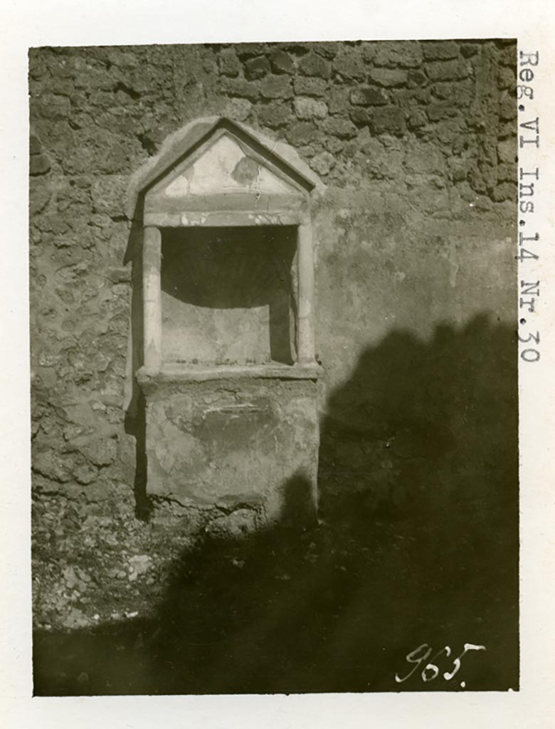 VI.14.30 Pompeii. Pre-1937-39. Aedicula against east wall of garden. 
Photo courtesy of American Academy in Rome, Photographic Archive. Warsher collection no. 965.
According to Boyce, against the east wall of the garden stands an aedicula (h.2.10). 
Above a solid base (0.88 by 0.28, h.0.85), two columns without capitals (h.0.72) support a pediment. 
In the tympanum is painted a large aquatic bird of reddish colour with wings spread.
It stands upon a black cloth, across its wings lies a black cord ending in a bow-knot, on each side of the bird stands a green marine goat.
The base of the aedicula is black, adorned with a painted garland. 
The rear wall within the shrine is hollowed out in the form of a seashell and painted in imitation of one.
In the south wall of the same garden is a niche with projecting floor and vaulted ceiling.
Its walls are adorned with painted plants, flowers and birds.
We can only speculate on the purpose of this niche. 
Presumably the aedicula is the lararium, the niche probably contained a figure of primarily decorative character.
See Boyce G. K., 1937. Corpus of the Lararia of Pompeii. Rome: MAAR 14. (p.53, no.203, and Pl. 35,1)
According to Giacobello, the painted decoration on the aedicula and architecture has disappeared, leaving only the stone podium and the niche. 
The wall was decorated with a rich garden painting.
Regarding the niche on the south wall of garden, originally painted with flowers, plants and birds, today disappeared, only the red plaster remains.
See Giacobello, F., 2008. Larari Pompeiani: Iconografia e culto dei Lari in ambito domestico. Milano: LED Edizioni. (p.275 no.V54)
