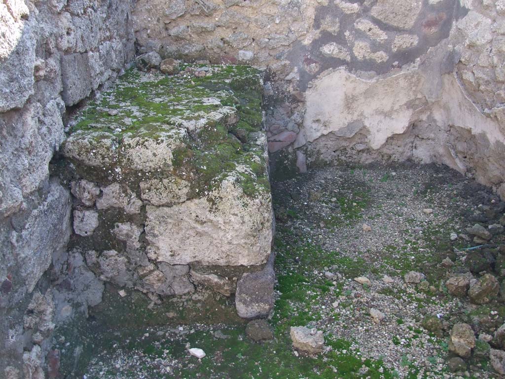 VI.14.43 Pompeii. December 2007. Room 10, stone bench in south-east corner of kitchen room.
According to Boyce, there was an arched niche in the west wall opposite a masonry structure.
This was in the small kitchen-like room on the south side of the atrium.
See Boyce G. K., 1937. Corpus of the Lararia of Pompeii. Rome: MAAR 14. (p.54, no.210) 
See Giacobello, F., 2008. Larari Pompeiani: Iconografia e culto dei Lari in ambito domestico. Milano: LED Edizioni. (p.180)