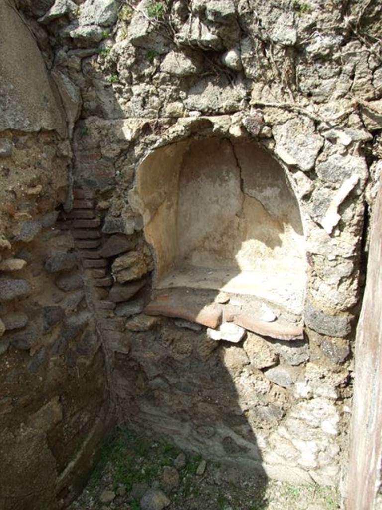 VI.15.6 Pompeii. March 2009. Room 9, north wall with niche. According to Boyce, in a little room on the south side of the house, is an arched niche in the north wall. It has white inside walls and projecting floor.
Just above the shrine were the marks made where some twenty-five nails had been driven into the wall. Not.Scavi, 1897, 31.
See Boyce G. K., 1937. Corpus of the Lararia of Pompeii. Rome: MAAR 14. (p.55, no.213) See Giacobello, F., 2008. Larari Pompeiani: Iconografia e culto dei Lari in ambito domestico.  Milano: LED Edizioni. (p.291)