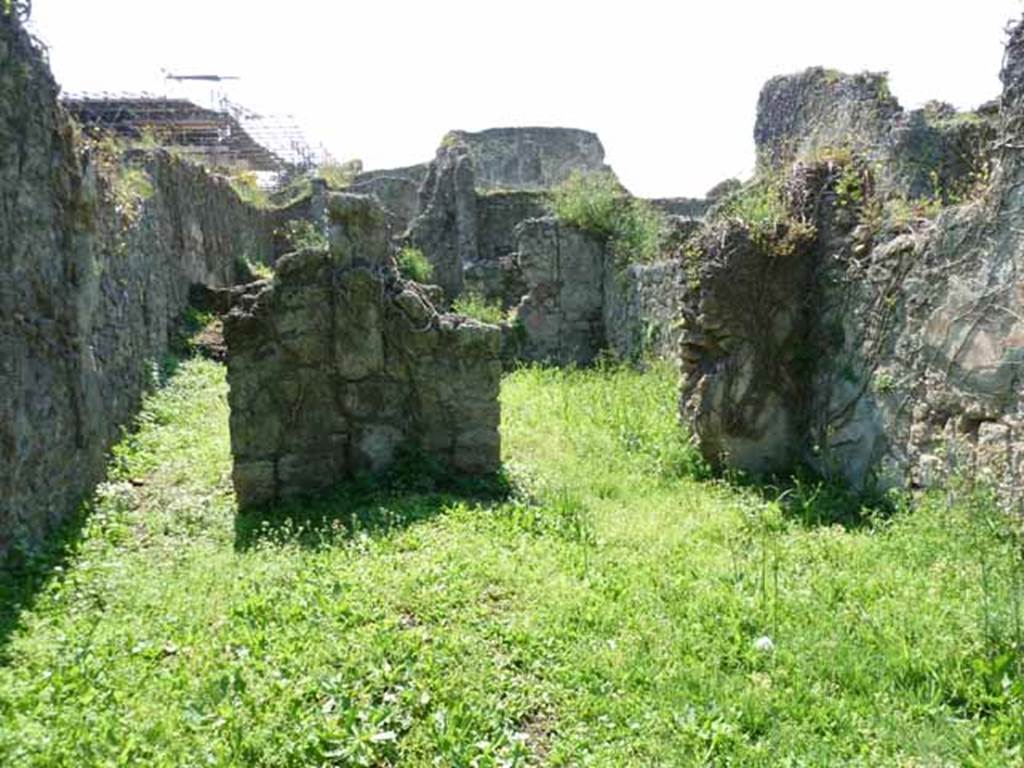 VI.16.11 Pompeii. May 2010. Looking west across shop to corridor to rear, on left, and rear room in north-west corner, on right. Originally, on the west wall between the corridor and the rear room was a lararium. According to Boyce, there was a ruined niche in the west wall, coated with white stucco bordered with red stripes. Red and green garlands were painted on the back wall of it. See Notizie degli Scavi di Antichità, 1908, p. 58. See Boyce G. K., 1937. Corpus of the Lararia of Pompeii. Rome: MAAR 14.  (p. 58, no.222).
