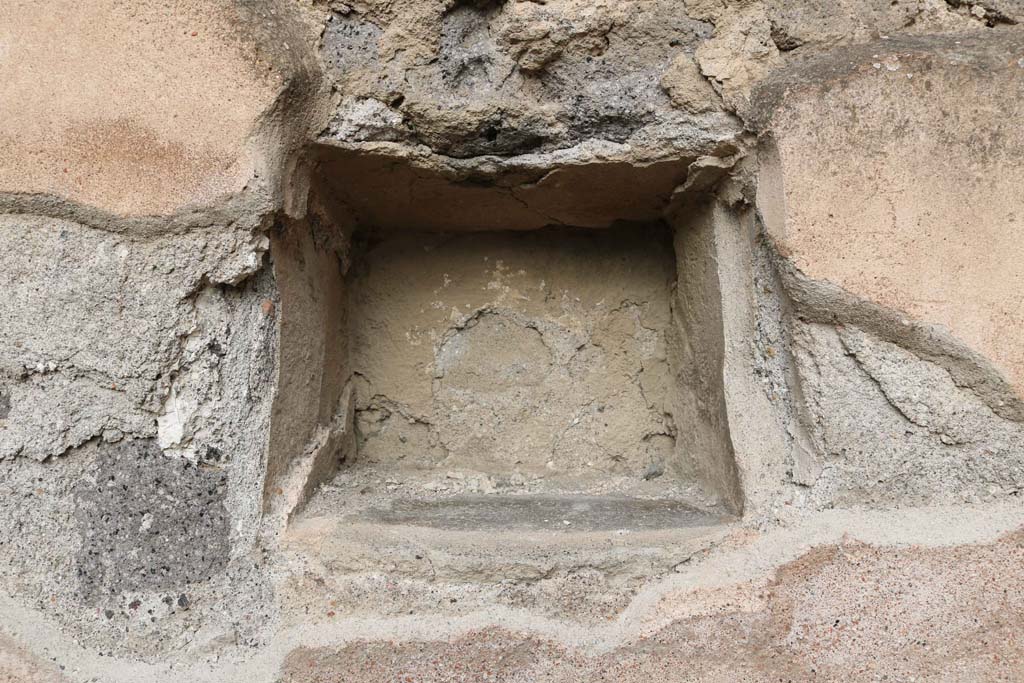 VII.1.11 Pompeii, December 2018. Niche/recess in north wall. Photo courtesy of Aude Durand.
According to Boyce – 
In the north wall is a square niche (0.28 square, d.0.24, h. above the floor 1.20), the walls of the niche were coated with the same white stucco which covered the walls of the room.
See Boyce G. K., 1937. Corpus of the Lararia of Pompeii. Rome: MAAR 14. (p.60, no.233).