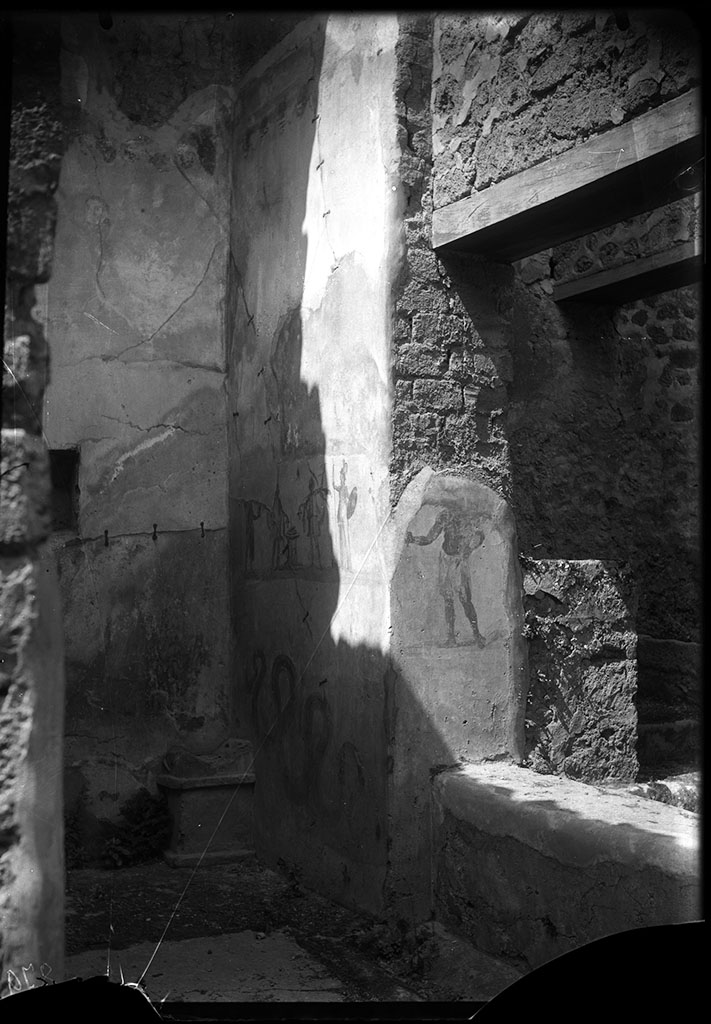 VII.2.14 Pompeii. 1931. North wall with remains of lararium painting with serpent.  
A painting of two gods and two Lares was above this.
See Fröhlich, T., 1991. Lararien und Fassadenbilder in den Vesuvstädten. Mainz: von Zabern. (p283: L80: T40,1.3).
According to Boyce, in the north wall on the east side of the lararium painting, was a window set in a recess which overlooked the kitchen.
On the west wall of this recess, around the corner, was painted a man.
See Boyce G. K., 1937. Corpus of the Lararia of Pompeii. Rome: MAAR 14. (p.61-2, 249, Pl. 23,1) 
DAIR 31.2453. Photo © Deutsches Archäologisches Institut, Abteilung Rom, Arkiv.