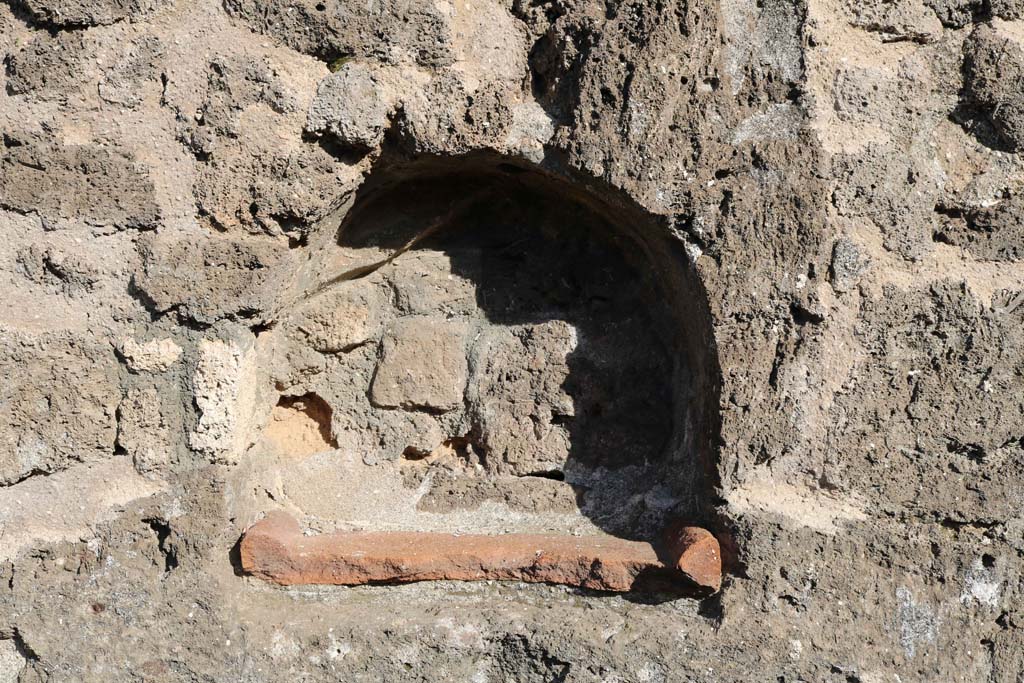 VII.3.12 Pompeii. December 2018. Arched niche set into east wall of shop. Photo courtesy of Aude Durand.
According to Boyce –
In the east wall of the taberna VII.3.11/12 is an arched niche (approximate size – h.0.40, w.0.50, d.0.20, h. above floor 1.20).
Its walls were coated with white stucco decorated with red lines.
See Boyce G. K., 1937. Corpus of the Lararia of Pompeii. Rome: MAAR 14.  (p.64, No.263)