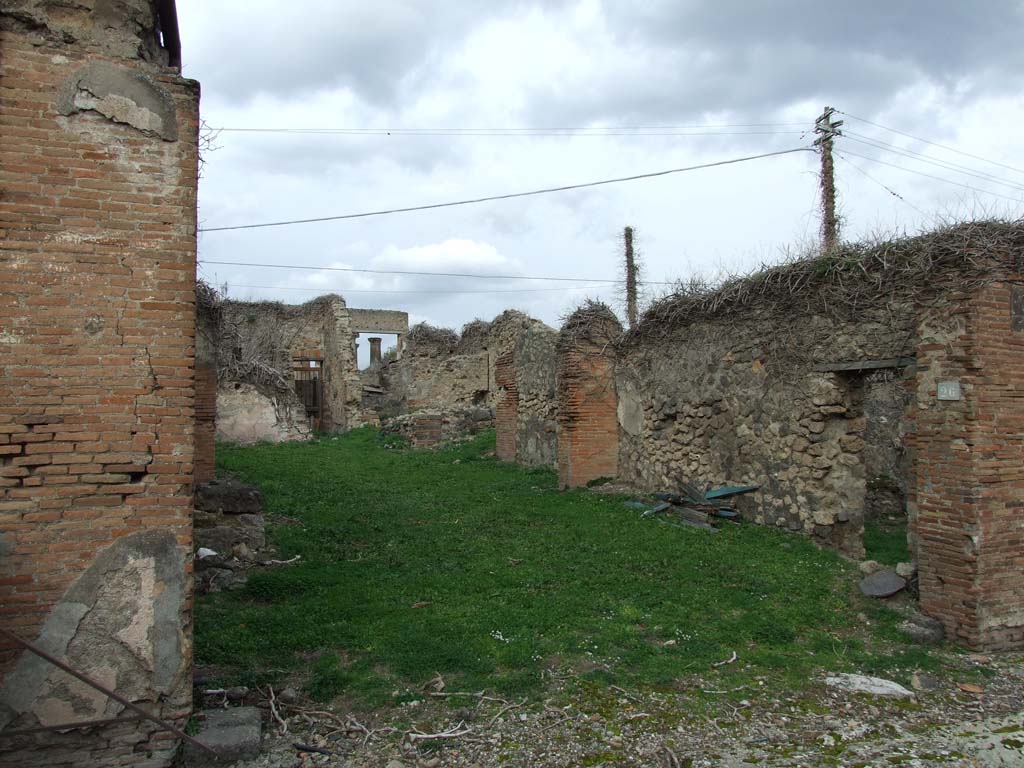 VII.4.26 Pompeii. December 2007. Shop entrance to workshop/dwelling. 
According to Fiorelli, the atrium with an impluvium would have been at the rear of the shop-room, on whose right side would have been positioned the ala, the storeroom containing the stairs to the upper rooms, and the cubiculum decorated with gladiatorial scenes.
At the rear, there was a small room bordered by the corridor, as well as a triclinium with entrance from the same corridor, which in its length gave access to three other rooms, a small garden and the kitchen, which had a separate latrine, and in the wall against the hearth showed a painting with Hercules before the altar, assisted by the Tibicine between the two Lares: in the lower part of the painting were two men with an amphora, and other amphorae on a cart. On the side wall, were the painted serpents and table. 
See Pappalardo, U., 2001. La Descrizione di Pompei per Giuseppe Fiorelli (1875). Napoli: Massa Editore. (p.90).