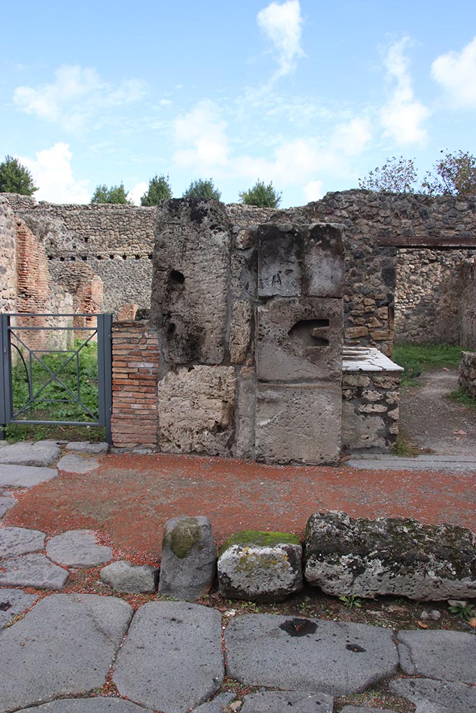 I.1.2 Pompeii, on right. October 2024. 
Pilaster on east side of Via Stabiana between I.1.3, on left, and I.1.2. Photo courtesy of Klaus Heese.