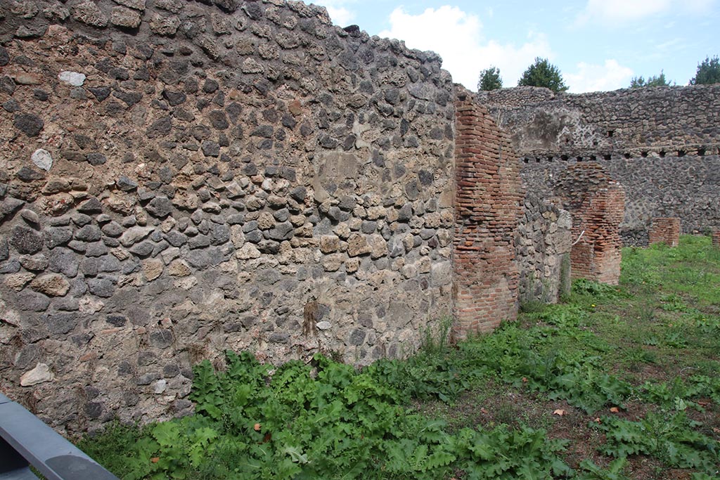 I.1.3 Pompeii, October 2024. 
North wall of room “a”, with north wall of room “b” with doorway into I.1.4, centre right. Photo courtesy of Klaus Heese.